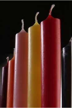 group of colorful cylindrical candles on a black background