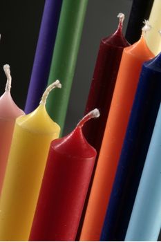 group of colorful cylindrical candles on a black background