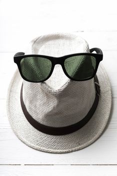 hat and sunglasses on white table