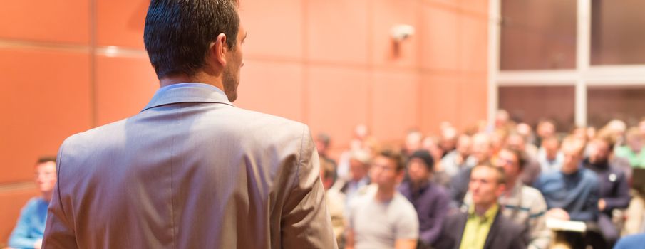 Speaker at Business Conference with Public Presentations. Audience at the conference hall. Business and Entrepreneurship concept. Background blur. Shallow depth of field.