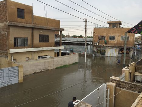 IRAQ, Baghdad: A street is flooded after heavy rainfall in the capital Baghdad, on October 29, 2015. Torrential rain caused chaos across several parts of Iraq, with the water causing thigh-high flooding on some Baghdad streets and damaging camps for the displaced.