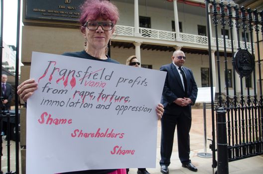 AUSTRALIA, Sydney: A woman holds a poster as protesters gather outside the annual general meeting for Transfield at the Sydney Mint on October 28, 2015. People arriving for the AGM were heckled and jeered before protesters were forced to move on. Transfield operates detention centres on Nauru and Papua New Guinea's Manus Island. 