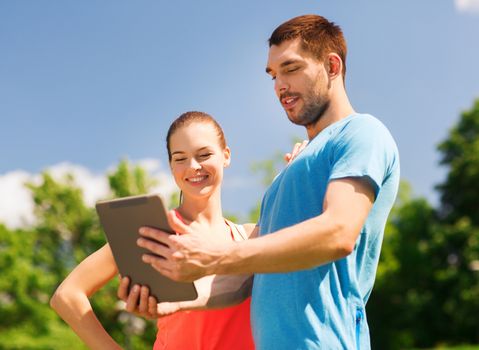 fitness, sport, friendship, technology and lifestyle concept - smiling couple with tablet pc computer outdoors