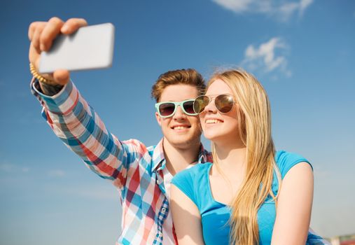 holidays, vacation, love and friendship concept - smiling couple having fun outdoors