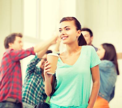 education concept - student holding take away coffee cup in college