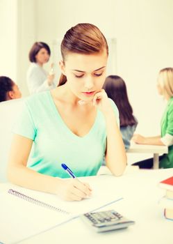 education concept - student girl with notebook and calculator