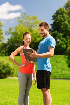 fitness, sport, friendship, technology and lifestyle concept - smiling couple with tablet pc computer outdoors