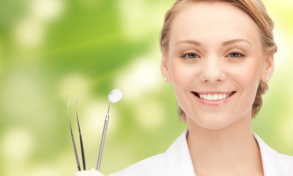 people, medicine, stomatology and healthcare concept - happy young female dentist with tools over green background