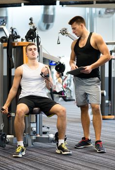 sport, fitness, equipment, lifestyle and people concept - man exercising on gym machine