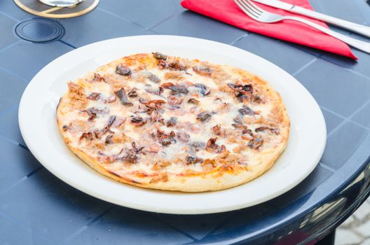 Delicious spicy pizza with seafood in a pizzeria.