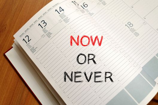 Now or never text concept write on notebook