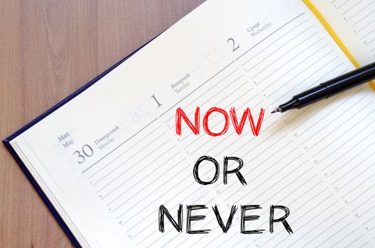 Now or never text concept write on notebook