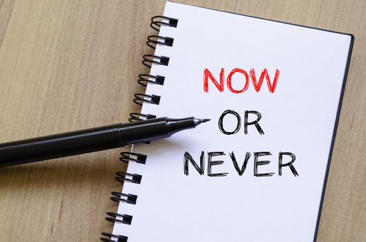 Now or never text concept write on notebook