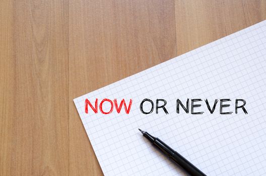 Now or never text concept write on notebook