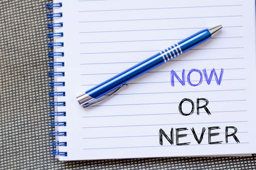 Now or never text concept write on notebook