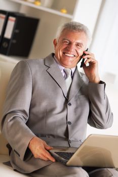 Happy Senior businessman talking on mobile phone.