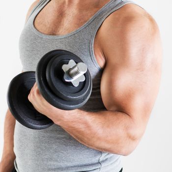 Young muscular man lifting the weights with biceps exercise. Close-up.