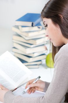 Beautiful Student girl sitting with many books and learning.