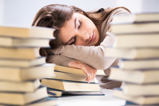 Tired student fell a sleep between many books, while learning. Selective focus.