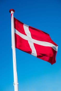 Danish flag on a flag pole in the wind