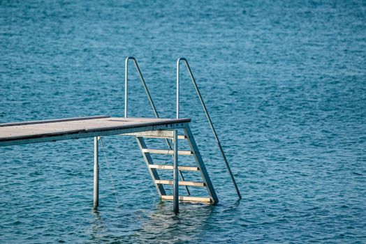 Jetty with a ladder at a blue ocean