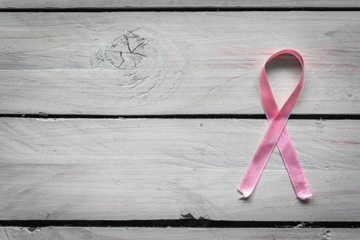 Womens health symbol in pink on wooden background