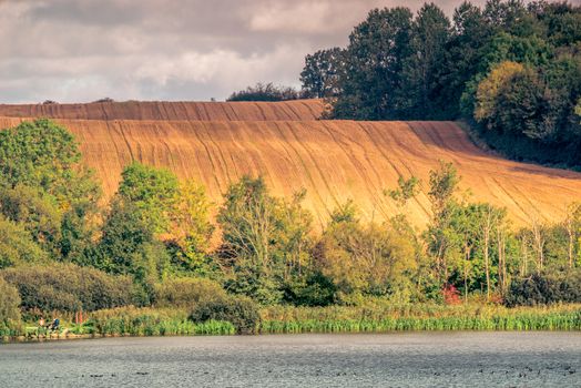 Agricultural hillside fields above a lake in the summer