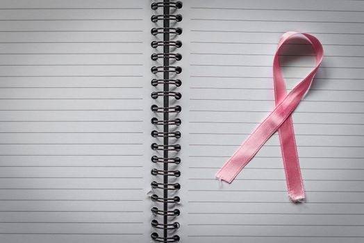 Breast cancer symbol in pink on a noteblok