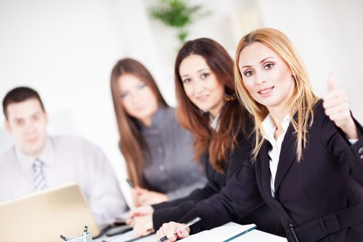 Happy Businesswoman showing thumbs up in the office, Looking at camera.