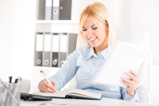 Businesswoman sitting at the table and working in the office.