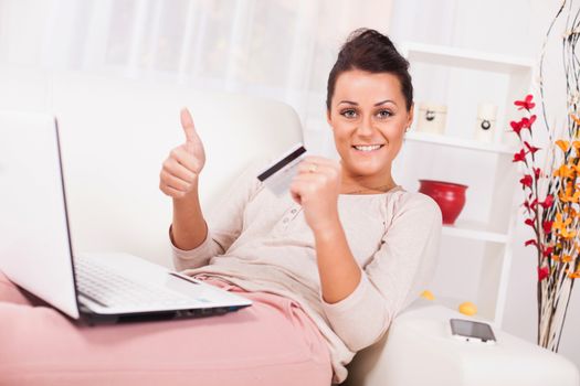 Beautiful young woman Shopping from home and showing thumbs up