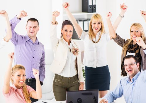 Group of a happy Successful Business People in the office, with raised arms looking at camera.