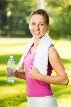 Beautiful young woman resting after exercising in the park.