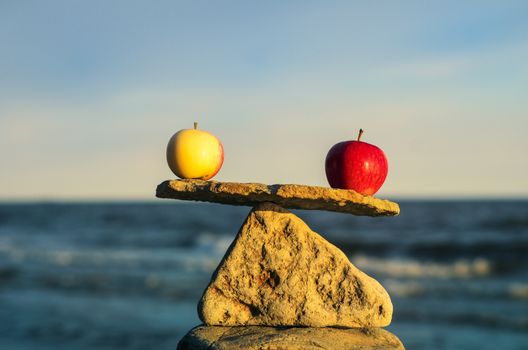 Two apples in balance on the top of stone