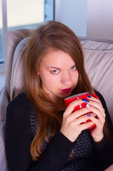 beautiful woman drinking coffee in the morning sitting by the window