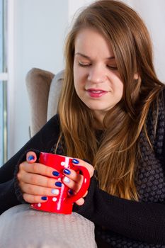 beautiful woman drinking coffee in the morning sitting by the window