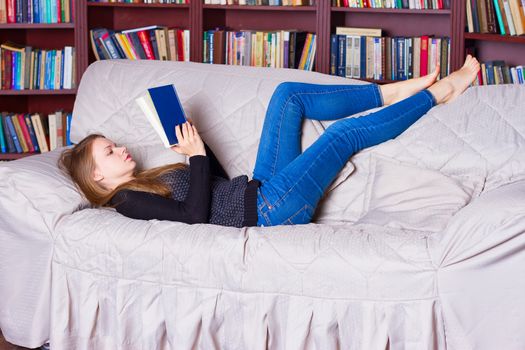 beautiful girl reading a book on sofa