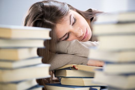 Tired student fell a sleep between many books, while learning. Selective focus.