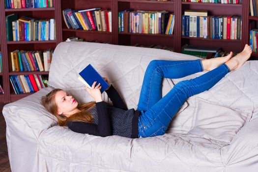 beautiful girl reading a book on sofa