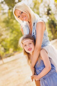 Beautiful, happy mother and daughter having fun in the park