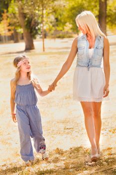 Beautiful, happy mother and daughter walking in the park