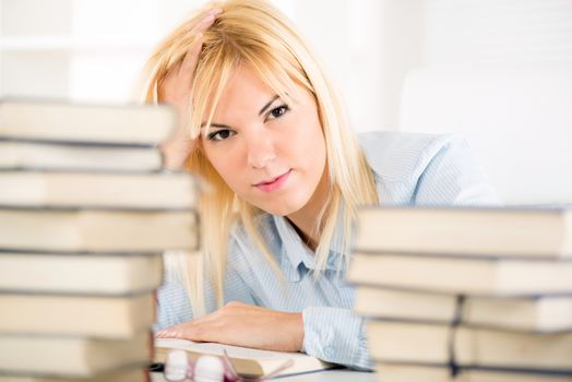 Beautiful Student girl learning and thinking between many books. 