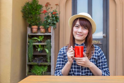 wear hat woman sitting in outdoor with warm drink relax