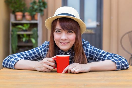 wear hat woman sitting in outdoor with warm drink relax