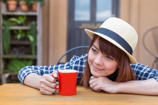 wear hat woman sitting in outdoor with warm drink relax