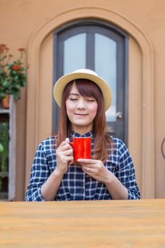 wear hat woman sitting in outdoor with warm drink relax