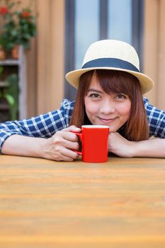 wear hat woman sitting in outdoor with warm drink relax