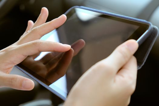 Woman Sitting in the Car and Using digital tablet.