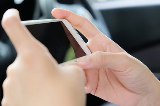 close up image of woman Sitting in the Car and Using Smart Phone
