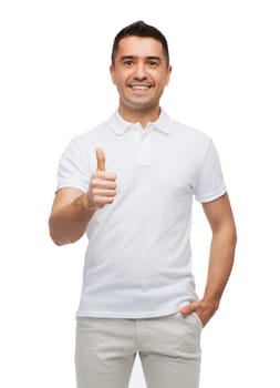 happiness, gesture and people concept - smiling man showing thumbs up